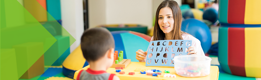 educator with child looking at alphabet