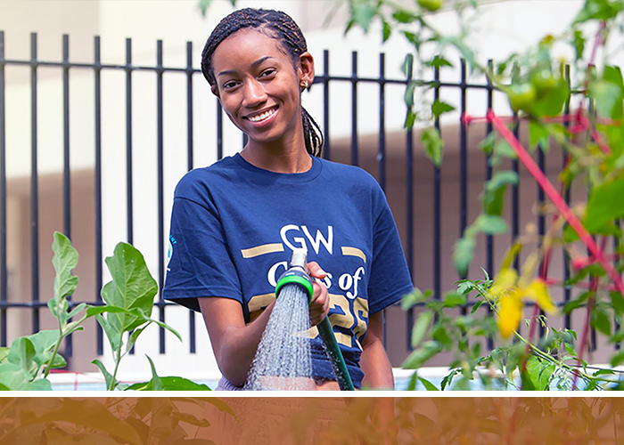 student watering plants in the GroW garden
